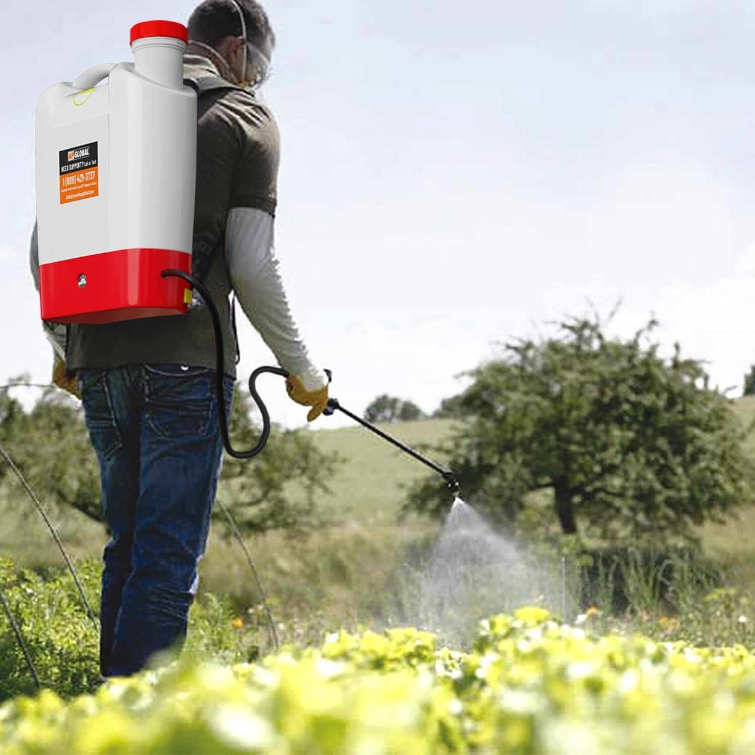 Person wearing the NPGLOBAL battery-powered backpack sprayer spraying crops in an open field